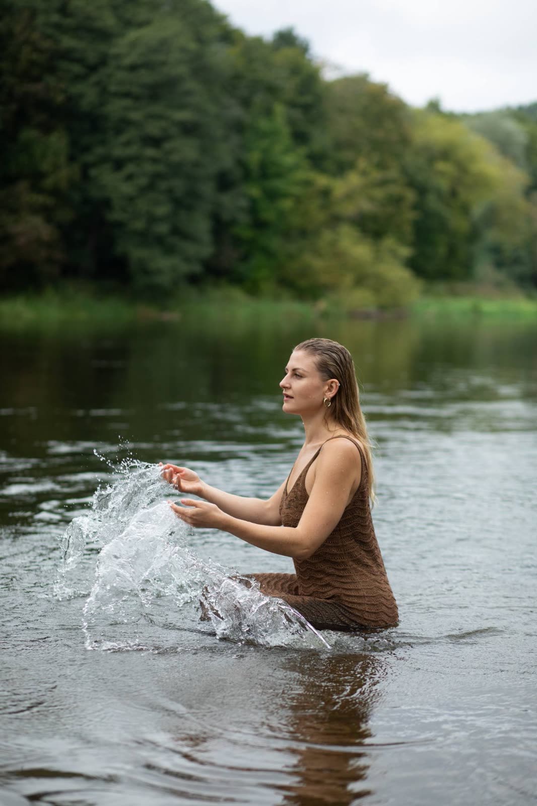 Vandens purslai aplink moterį upėje